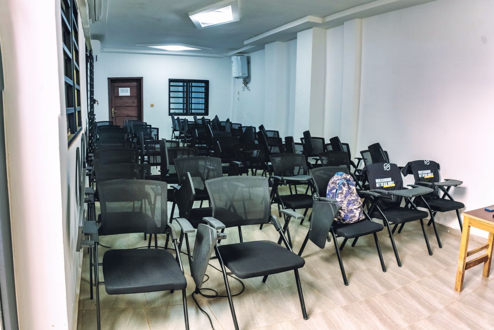 Salle de formation vide, rangées de sièges à tablette