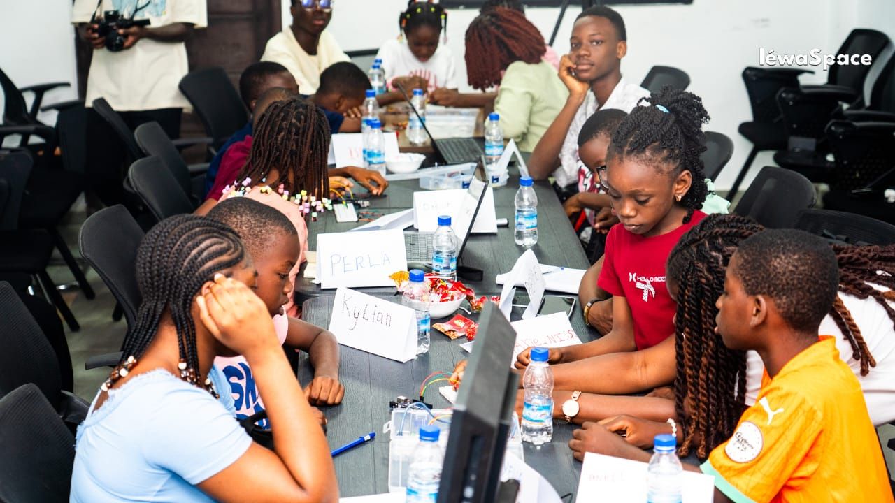 Enfants en atelier autour d'une table, ordinateurs et composants